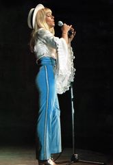 Sylvie Vartan en chemisier à volants et pantalon bleu à galons dorés en Afrique pour sa tournée 1969