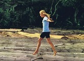 Sylvie Vartan en Côte d'Ivoire en 1969 marche sur des troncs de bois flottants